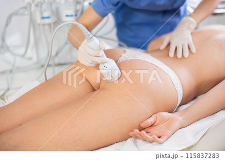 Young female cosmetologist performing whitening procedure on young woman buttocks Young female cosmetologist performing whitening procedure on young woman buttocks 115837283
