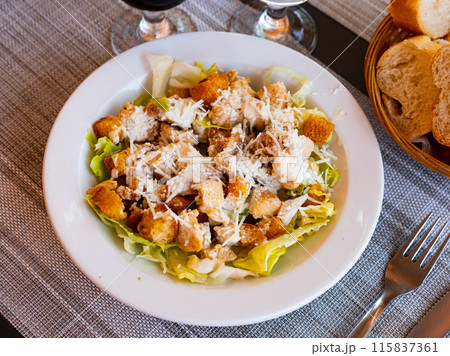 Cesar salad with chicken, lettuce and cheese parmesan 115837361