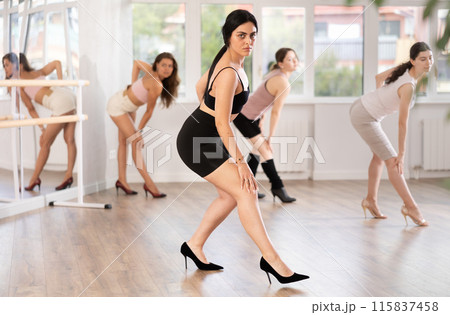 Young brunette performing high heels choreography at group class Young brunette performing high heels choreography at group class 115837458