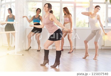 Dynamic female dancers rehearsal, performing sensual choreography in high heels, epitomizing grace in studio Dynamic female dancers rehearsal, performing sensual choreography in high heels, epitomizing grace in studio 115837540
