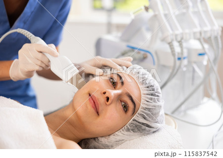 Young woman cosmetologist doing exfoliation procedure to young woman Young woman cosmetologist doing exfoliation procedure to young woman 115837542