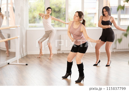 During lesson, girl learn to move and perform dance in heels with women companions 115837799