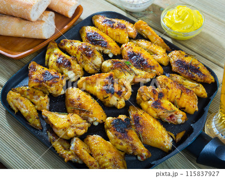 Fried chicken wings on grill pan with sauce Fried chicken wings on grill pan with sauce 115837927