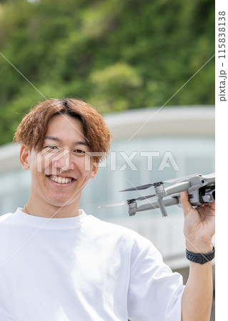 晴れの屋外でドローン撮影を楽しむ日本人男性｜ドローンイメージ 115838138