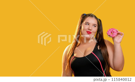 Sweet pastries. Pink yummy. Diet problem. Cute curvy overweight woman tasty sugary bitten donut white sprinkles in black swimsuit isolated on yellow empty space background. 115840012
