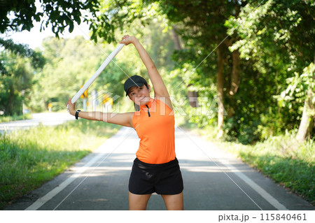 Healthy woman warming up stretching her arms and looking away in the road outdoor 115840461