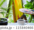 植物とキャンバス、テーブルの上にあるコーヒーカップ 115840466