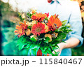 オレンジの花束を手渡す女性の手 115840467