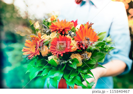 オレンジの花束を手渡す女性の手 オレンジの花束を手渡す女性の手 115840467
