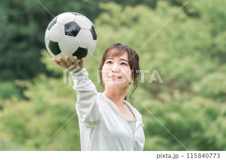 運動場でサッカーボールを持つサッカーファン・サポーターの日本人女性 運動場でサッカーボールを持つサッカーファン・サポーターの日本人女性 115840773