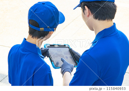 タブレットを見て相談する作業員 115840933