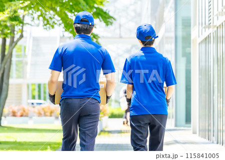 荷物を運ぶ作業員の後ろ姿 115841005