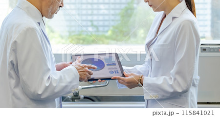 タブレットを見ながら相談する医師・研究者 115841021