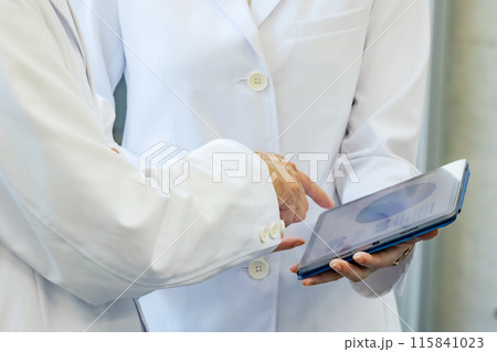 タブレットを見ながら相談する医師・研究者 タブレットを見ながら相談する医師・研究者 115841023