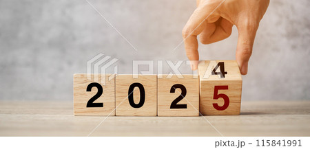 hand flipping block 2024 to 2025  text on table. Resolution, strategy, plan, goal, motivation, reboot, business and New Year holiday concepts 115841991
