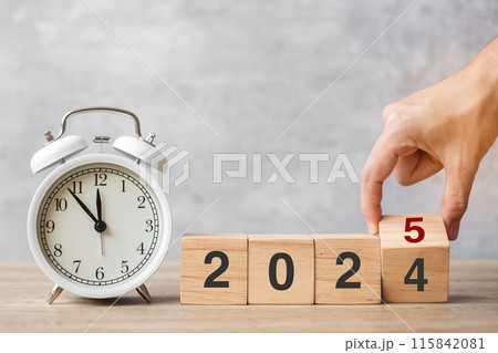 Happy New Year with vintage alarm clock and hand flipping 2024 change to 2025 block. Christmas, New Start, Resolution, countdown, Goals, Plan, Action and Motivation Concept Happy New Year with vintage alarm clock and hand flipping 2024 change to 2025 block. Christmas, New Start, Resolution, countdown, Goals, Plan, Action and Motivation Concept 115842081