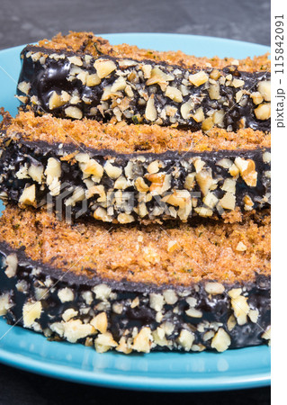 Pieces of zucchini dough with nuts and raisins on blue plate 115842091