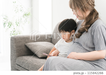 スマホを見る子供と子守をする妊娠中のママ・母親・妊婦 115842266