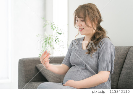 体温計を見て安心する日本人妊婦 体温計を見て安心する日本人妊婦 115843130