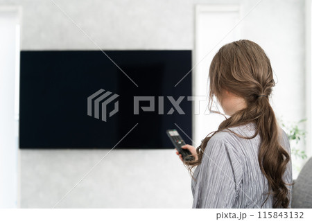 テレビのリモコンを持つ妊婦の女性（産休・産前産後休業） 115843132