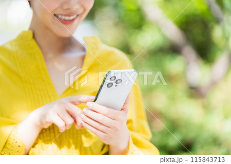 屋外でスマホを操作する女性。 115843713