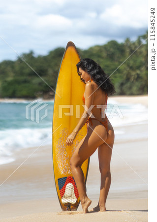Bikini Surfer Woman with Yellow Surfboard on Sandy Beach 115845249