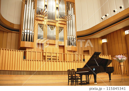 コンサートホールに設置されっているパイプオルガンとグランドピアノ 115845341