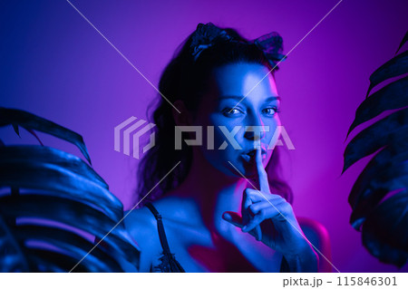 Mysterious Cat Woman in Neon Lights with Shushing Gesture at Party 115846301
