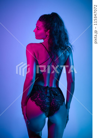 Elegant Model in Black Lace Lingerie with Neon Blue and Pink Lighting Elegant Model in Black Lace Lingerie with Neon Blue and Pink Lighting 115847072