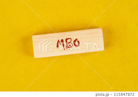 Management by Objectives MBO written on wooden blocks on a bright yellow mustard background 115847872