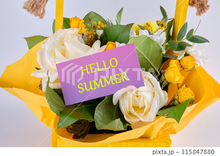 Conceptual hello summer symbol. HELLO SUMMER on a purple business card in a basket with flowers 115847880