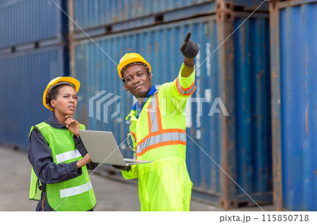 African Black Worker Teamwork in Cargo Port Shipping Industrial in Yellow Hard Hat Safety Vest on Duty. Foreman or Supervisor in Container Ship Yard Terminal. 115850718