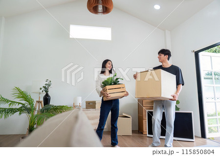 Happy Couple Moving into New Modern House with Boxes and Plants, Starting Fresh in Their New Home Happy Couple Moving into New Modern House with Boxes and Plants, Starting Fresh in Their New Home 115850804