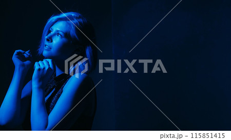 Hoping woman. Depression overcome. Female raising hands looking up expecting help mental mood disorder neon blue lights dark background empty space. Hoping woman. Depression overcome. Female raising hands looking up expecting help mental mood disorder neon blue lights dark background empty space. 115851415