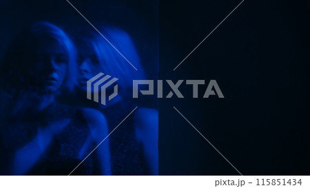 Dual personality. Blur silhouette. Internally suffering sad woman out of focus mental disorder neon blue color double exposure dark free space. 115851434