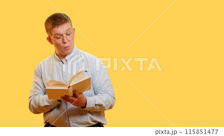Smart student. Exam preparation. Incredible facts. Portrait of chubby overweight surprised man learning textbook with interest study time isolated on yellow empty space background. Smart student. Exam preparation. Incredible facts. Portrait of chubby overweight surprised man learning textbook with interest study time isolated on yellow empty space background. 115851477