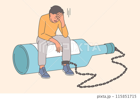 Man suffers from alcohol addiction or hangover, sits on large bottle with chain on leg 115851715