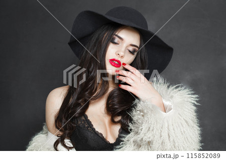 Pretty young adult woman fashion model with bright make-up and long wavy hair wearing blue hat Pretty young adult woman fashion model with bright make-up and long wavy hair wearing blue hat 115852089