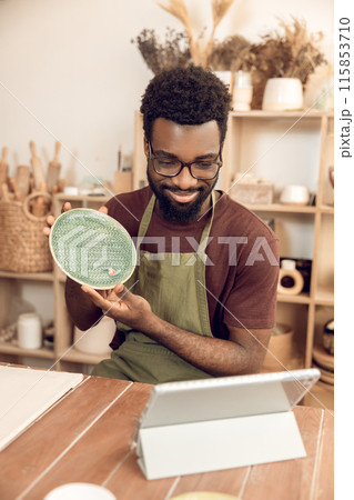 African american sculptor conducting a n online tutorial and looking contented African american sculptor conducting a n online tutorial and looking contented 115853710