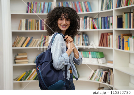 Cute woman in the library smiling nicely and looking contented 115853780