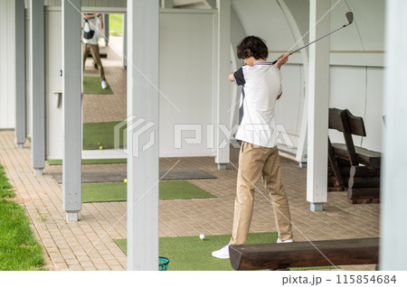 Young golfer exercising in playing golf and looking involved Young golfer exercising in playing golf and looking involved 115854684