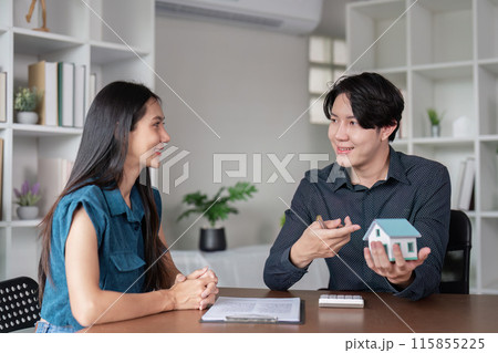Real Estate Agent Discussing Property Sale Contract with Client in Modern Office Setting 115855225