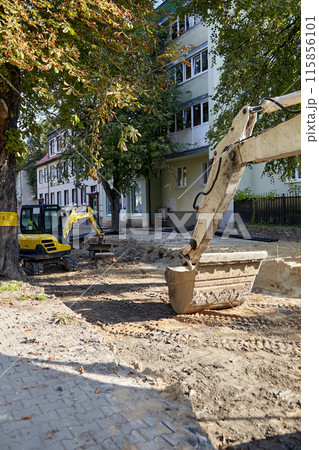 Road repair equipment excavators at a construction site in the city Road repair equipment excavators at a construction site in the city 115856101