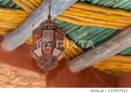 Old ancient Moroccan lantern hanging from a traditionally built wooden ceiling, Agadir 115857012