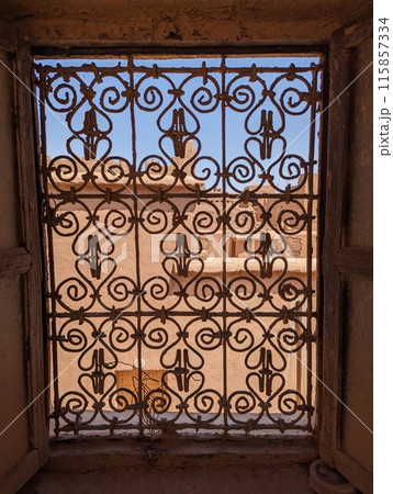 Ornate traditional window grid of a berber house ruin in the city center of Amezrou 115857334