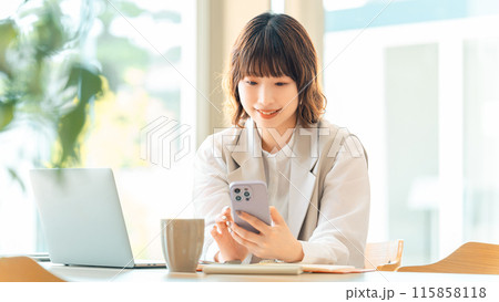 スマホを使う笑顔の女性・ビジネスウーマン 115858118
