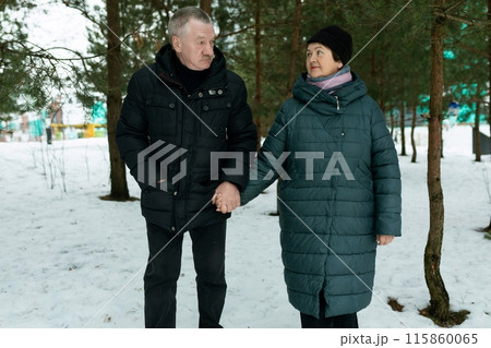 Happy elderly couple feels tenderness for each other while walking in the park Happy elderly couple feels tenderness for each other while walking in the park 115860065