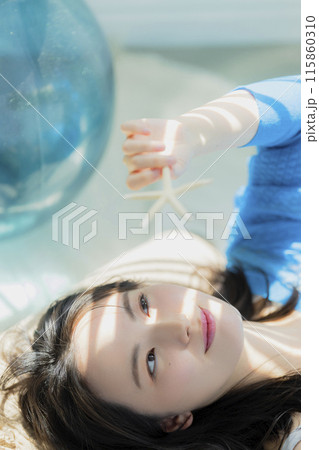 仰向けに寝転がる青い服の女性 仰向けに寝転がる青い服の女性 115860310