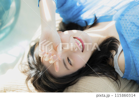 仰向けに寝転がる青い服の女性 仰向けに寝転がる青い服の女性 115860314