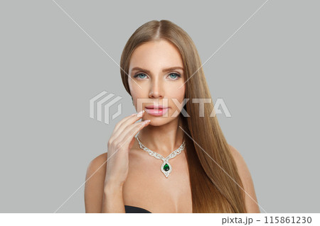 Posing woman with makeup wearing jewelry necklace with sapphire and diamond on grey background Posing woman with makeup wearing jewelry necklace with sapphire and diamond on grey background 115861230